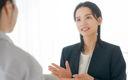 広告運用の入稿管理やデータ分析について、パソコン画面を見ながら業務改善方法を説明するコクーの支援担当者